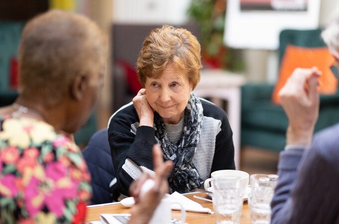 A woman listening in a group discussion.