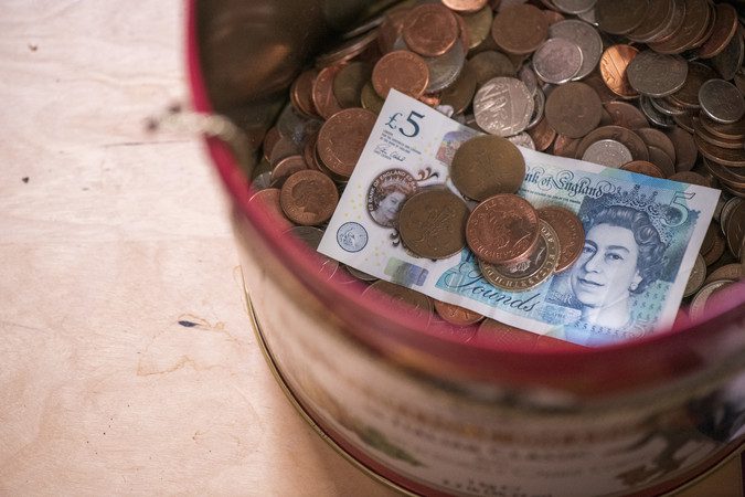 Pot of money on a table.