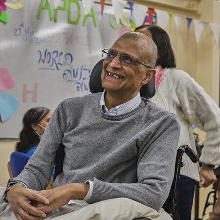 A man in a wheelchair smiling.