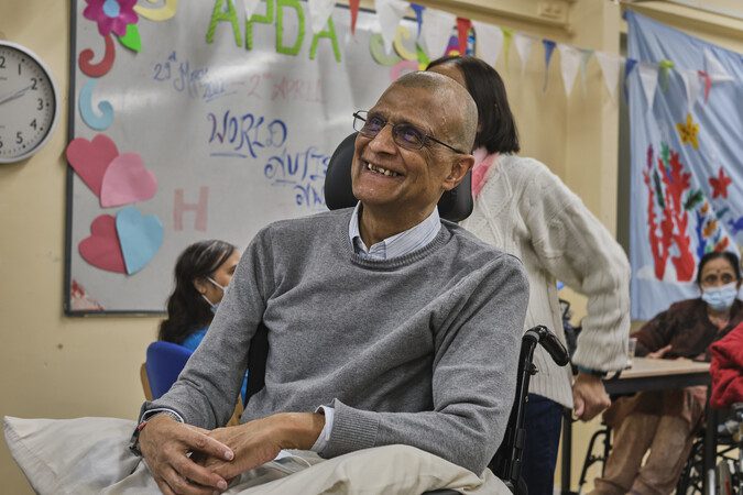 A man in a wheelchair smiling.